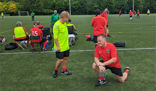 Walkign soccer players warming up beside a turf fieldbefore a game