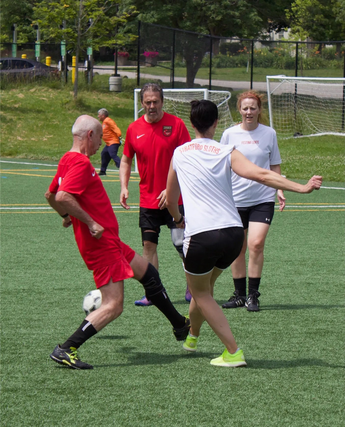 older adult men and women enjoying walking soccer on a turf field